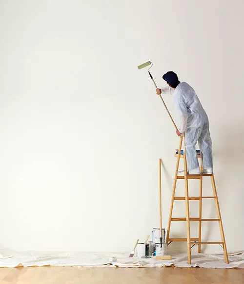 house-painter-standing-on-ladder-painting-a-large-wall